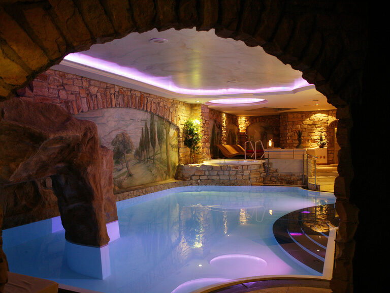 Innenpool mit schöner Beleuchtung, Grotte mit Gegenstrom Anlage im SPA Bereich des Hotels Der Heidehof in Ingolstadt